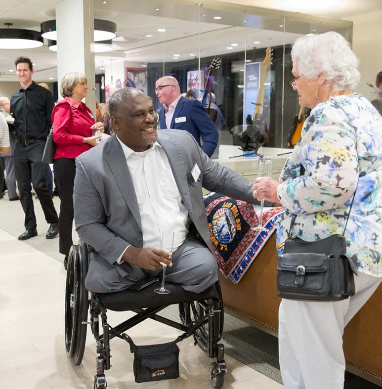 Greg Gadson speaks to a guest at the Education and Outreach Center inside the Gary Sinise Foundation.