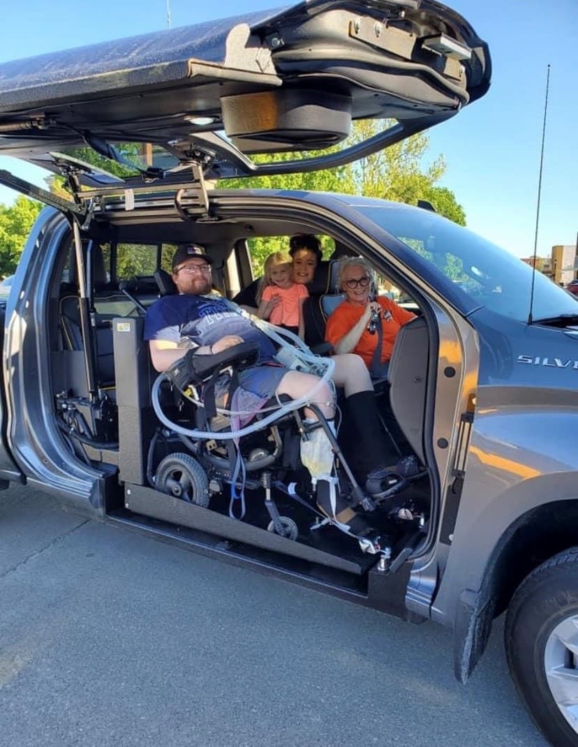 The gull wing-link opening of the specially adapted pickup truck allows easy access into and out of the vehicle for Austin Gibson.